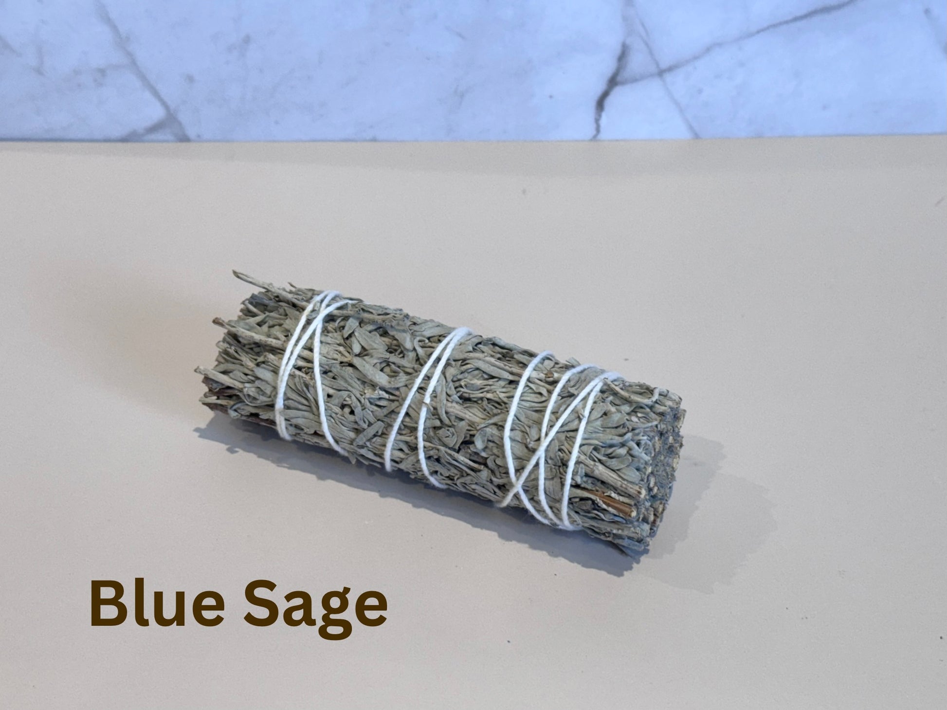 Bundled blue sage on a light surface with a marble background